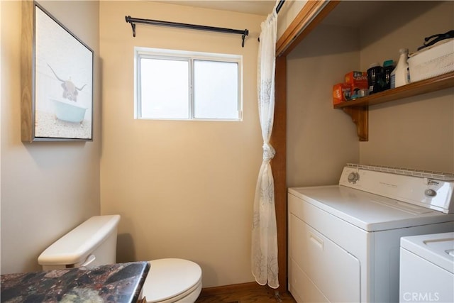 laundry area with washing machine and dryer, laundry area, and dark wood finished floors