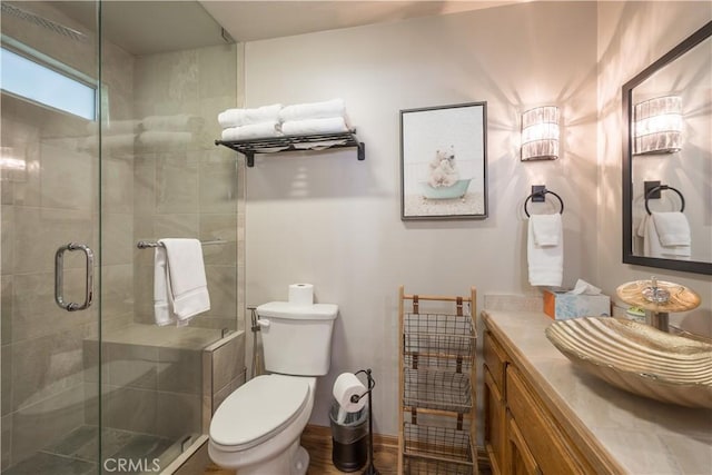 full bath with vanity, a shower stall, and toilet