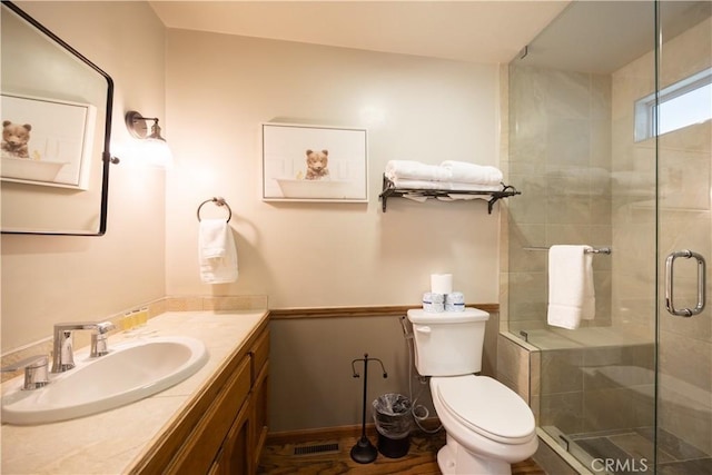 full bath with a shower stall, toilet, vanity, and visible vents
