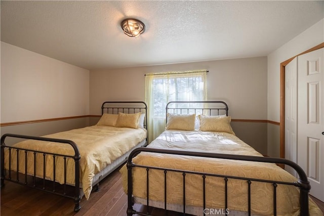 bedroom featuring a textured ceiling and dark wood-style floors