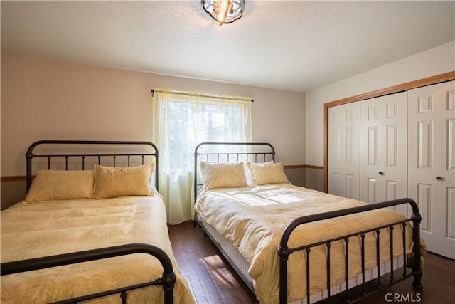 bedroom with wood-type flooring, a textured ceiling, and a closet