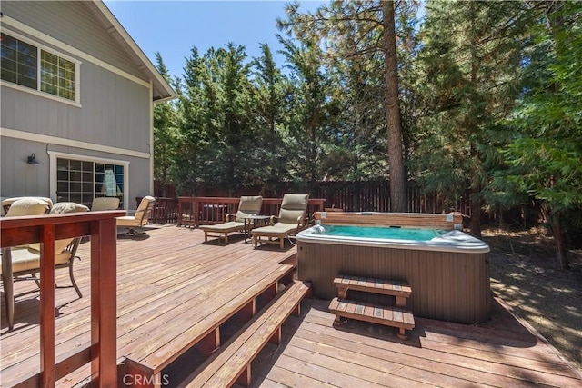 wooden deck featuring outdoor dining space, a hot tub, and fence