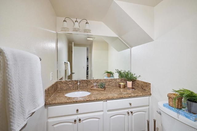 half bathroom featuring vanity and toilet