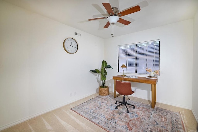 carpeted home office featuring ceiling fan, visible vents, and baseboards