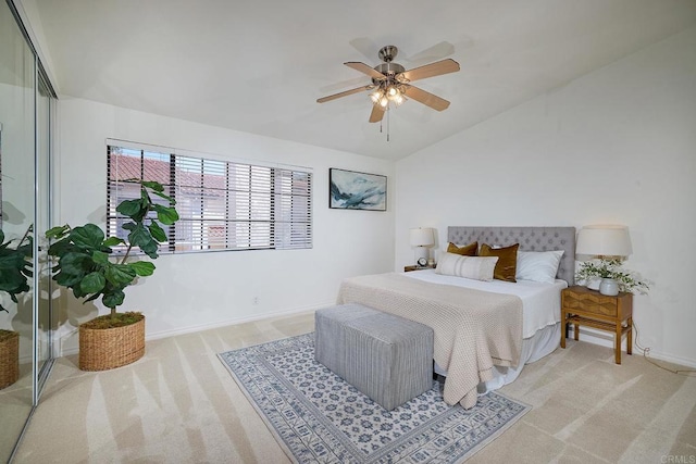 carpeted bedroom with a closet, a ceiling fan, baseboards, and vaulted ceiling