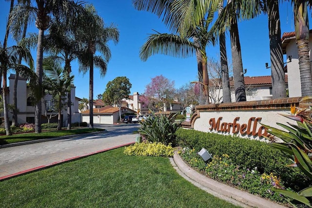 community sign featuring a residential view and a yard