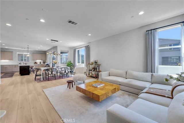 living area with light wood-style flooring, visible vents, and recessed lighting