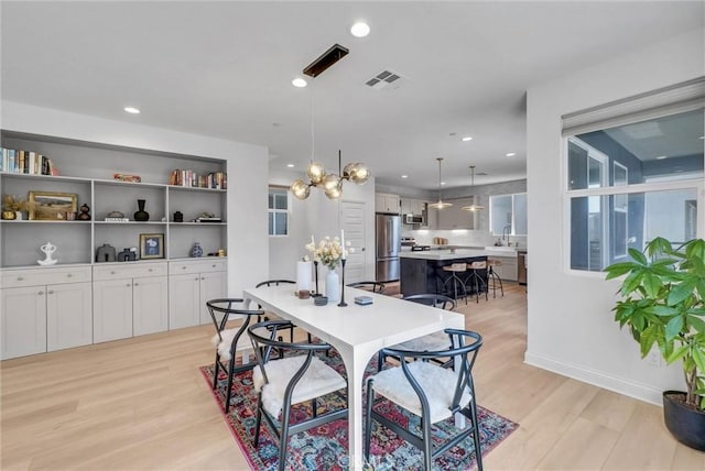 dining room with light wood-type flooring, visible vents, and recessed lighting