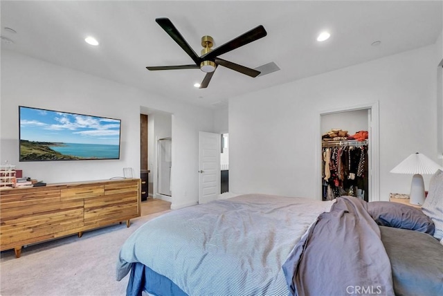 bedroom with a closet, a spacious closet, a ceiling fan, recessed lighting, and light carpet