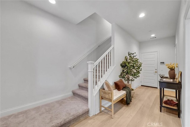 stairs featuring visible vents, baseboards, recessed lighting, and wood finished floors