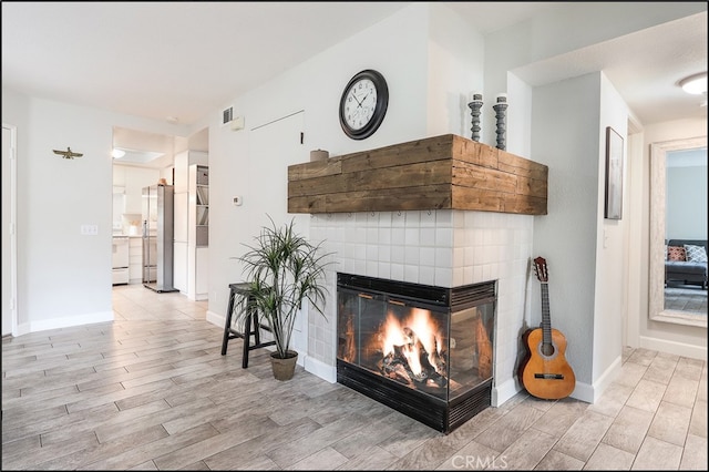 3 Hillrose, Aliso Viejo, CA 92656 - living area with visible vents, baseboards, light wood-style flooring, and a multi sided fireplace