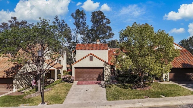 view of front of property with concrete driveway, a front yard, stucco siding, and a tile roof