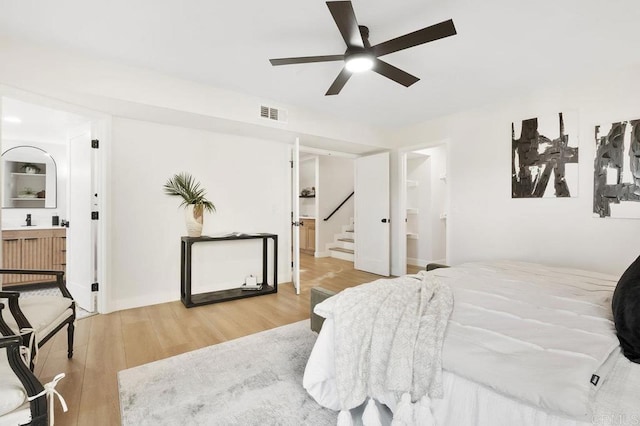 bedroom featuring visible vents, ensuite bathroom, and light wood-style floors