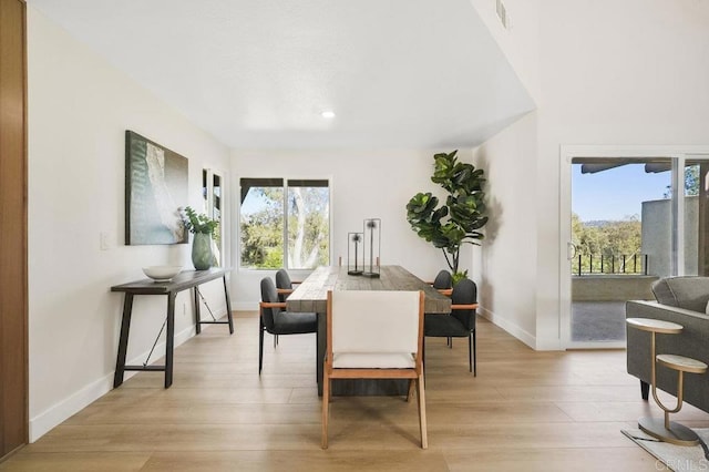 dining area with light wood-style flooring, baseboards, and recessed lighting