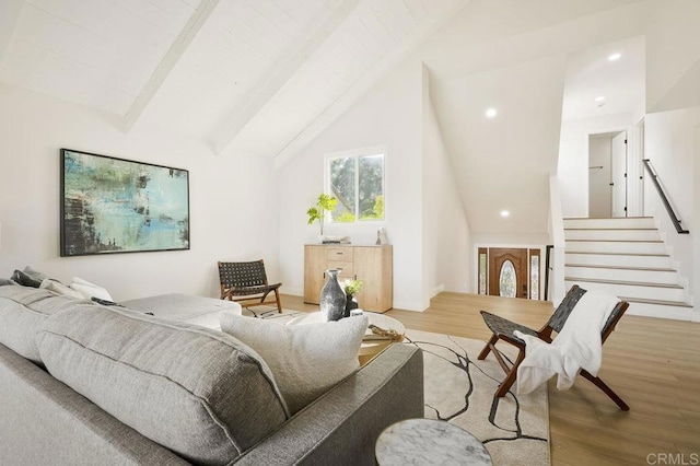 living room with recessed lighting, light wood-style flooring, and vaulted ceiling with beams