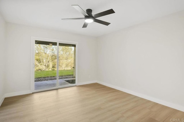 spare room with light wood finished floors, baseboards, and a ceiling fan