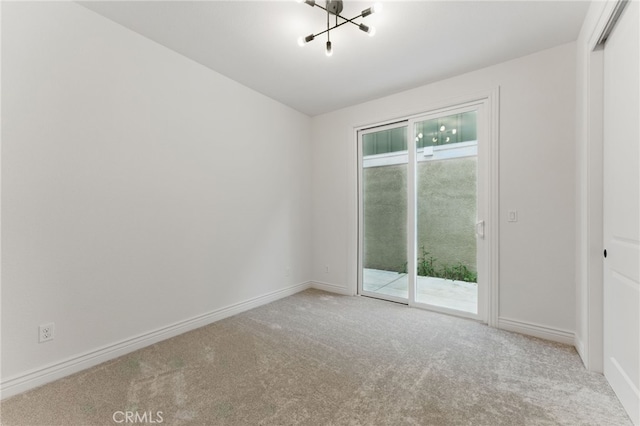 carpeted spare room with a healthy amount of sunlight, a notable chandelier, and baseboards