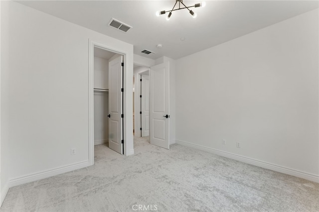unfurnished bedroom featuring baseboards, visible vents, a spacious closet, and carpet floors
