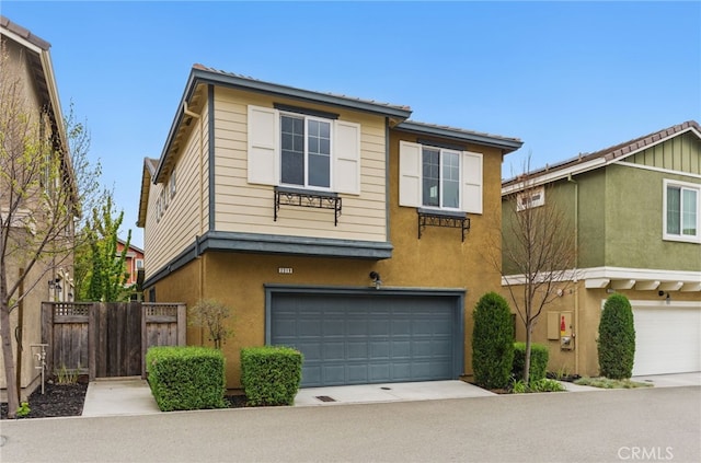 townhome / multi-family property featuring fence, stucco siding, concrete driveway, and an attached garage