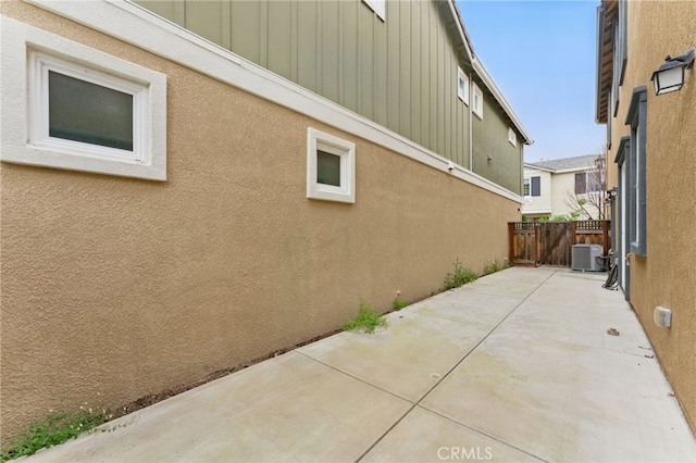 view of home's exterior featuring fence, stucco siding, board and batten siding, and a patio area
