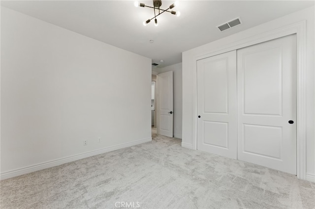 unfurnished bedroom featuring carpet flooring, a closet, visible vents, and baseboards