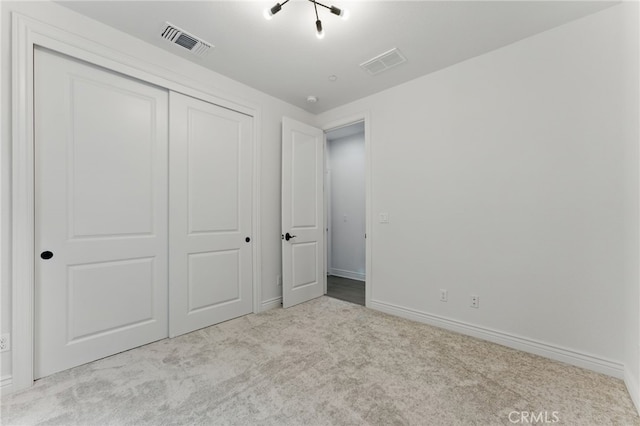 unfurnished bedroom with a closet, visible vents, carpet, and baseboards