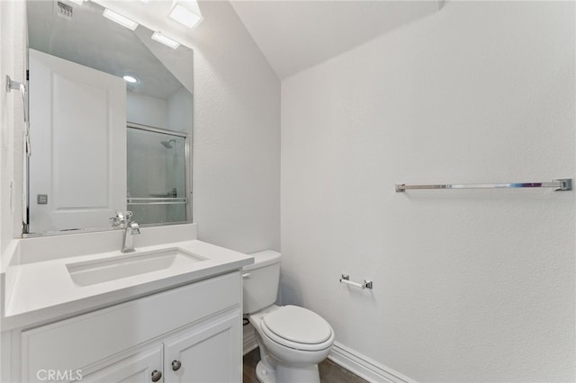 bathroom featuring vanity, toilet, visible vents, baseboards, and walk in shower