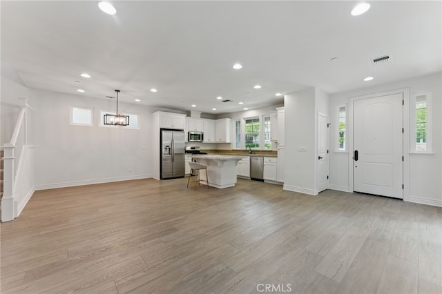 kitchen featuring recessed lighting, a breakfast bar, visible vents, white cabinets, and appliances with stainless steel finishes
