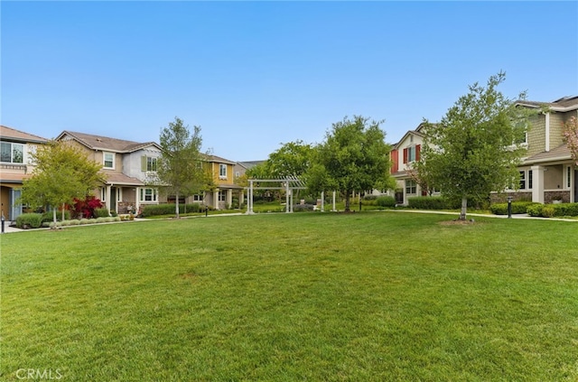 view of yard with a pergola and a residential view