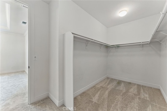 spacious closet with visible vents and light colored carpet