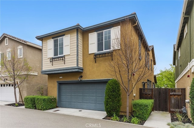 view of front of home featuring fence, driveway, stucco siding, and a garage