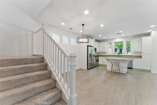 stairs featuring recessed lighting, an inviting chandelier, wood finished floors, and baseboards