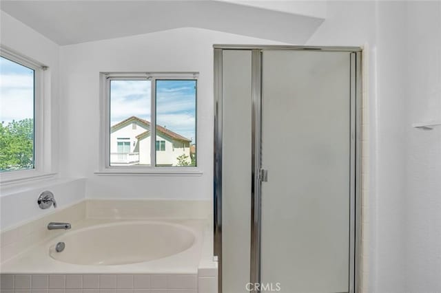 bathroom with a stall shower and a garden tub