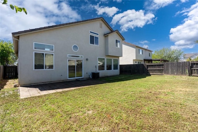 rear view of property featuring central AC unit, a patio area, a lawn, a fenced backyard, and stucco siding