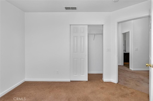 unfurnished bedroom featuring a closet, carpet, visible vents, and baseboards