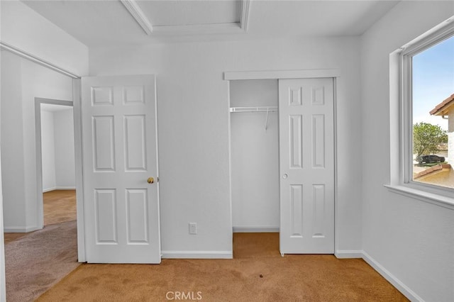 unfurnished bedroom featuring a closet, carpet flooring, and baseboards