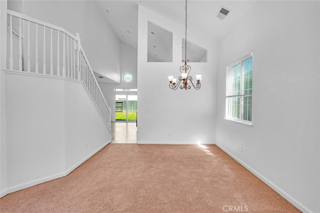 spare room with high vaulted ceiling, a wealth of natural light, visible vents, and carpet floors