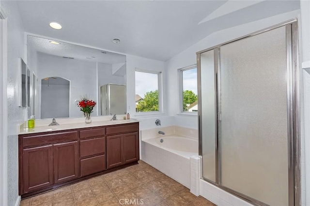 bathroom featuring a stall shower, a garden tub, a sink, and lofted ceiling