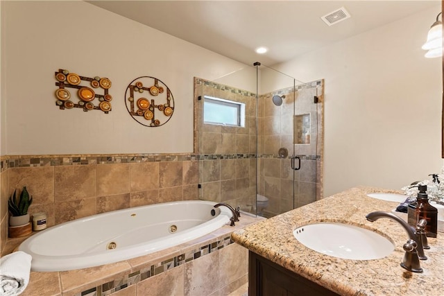 bathroom with a tub with jets, visible vents, a sink, a stall shower, and double vanity