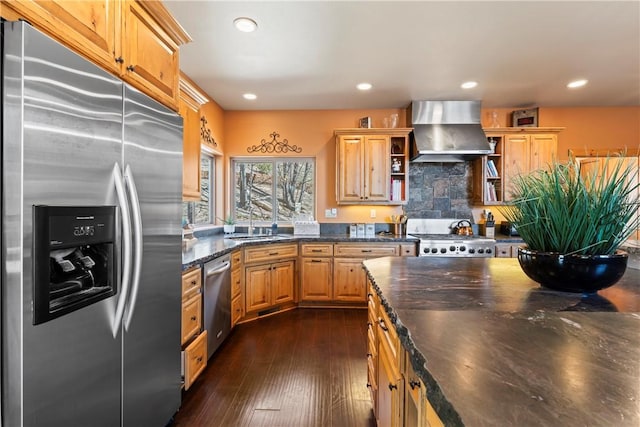 kitchen featuring recessed lighting, wall chimney exhaust hood, dark wood finished floors, stainless steel appliances, and a sink