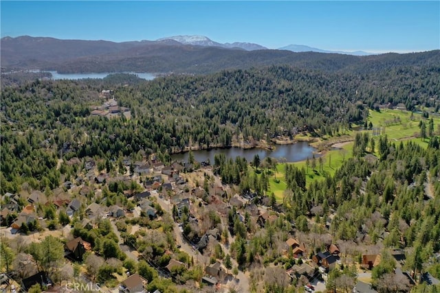 birds eye view of property with a wooded view and a water and mountain view