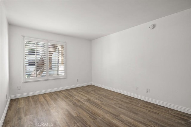 unfurnished room featuring wood finished floors and baseboards
