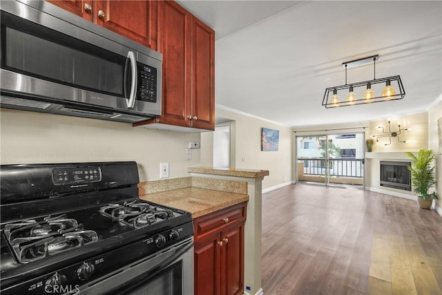 kitchen with open floor plan, gas range, stainless steel microwave, and dark brown cabinets