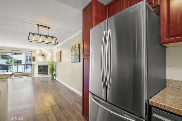 kitchen with open floor plan, freestanding refrigerator, dark brown cabinets, and wood finished floors
