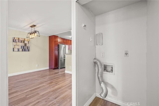 washroom featuring baseboards, light wood-type flooring, electric dryer hookup, washer hookup, and laundry area