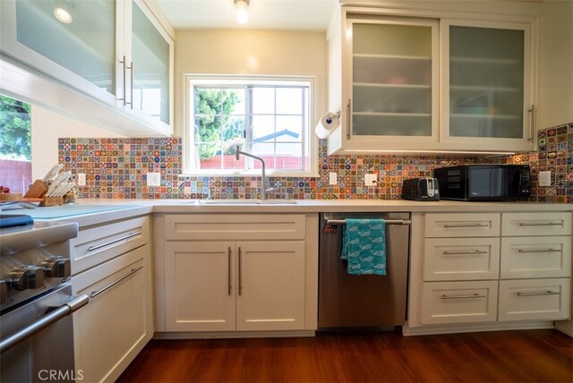 kitchen featuring appliances with stainless steel finishes, a sink, dark wood-style floors, and plenty of natural light