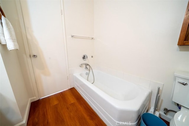 full bathroom featuring toilet, wood finished floors, and a bathtub