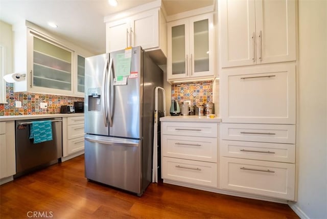 kitchen with tasteful backsplash, dark wood-style floors, white cabinetry, light countertops, and appliances with stainless steel finishes