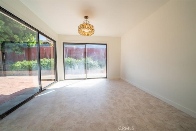 carpeted spare room featuring baseboards