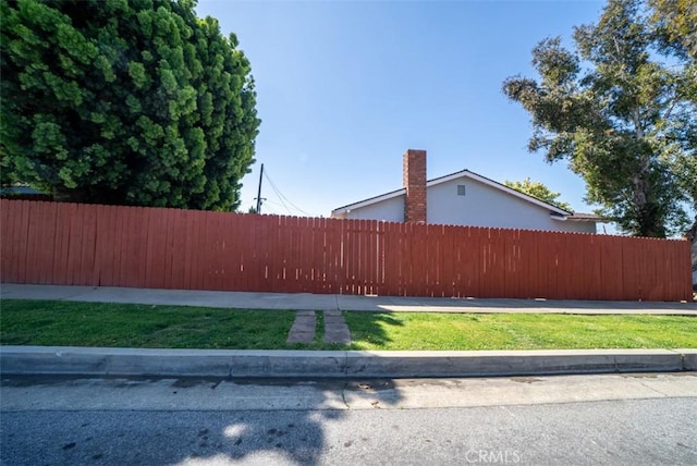 view of home's exterior featuring a yard, fence, and a chimney